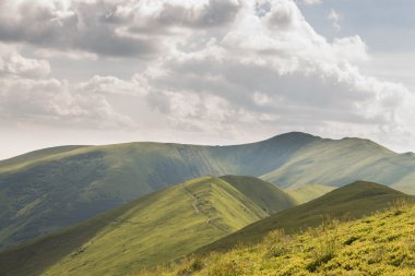 Yeşil dağlar ve mavi bulutlu gökyüzü