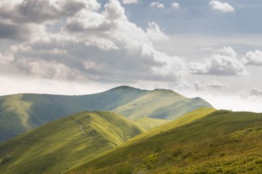 Yeşil dağlar ve mavi bulutlu gökyüzü