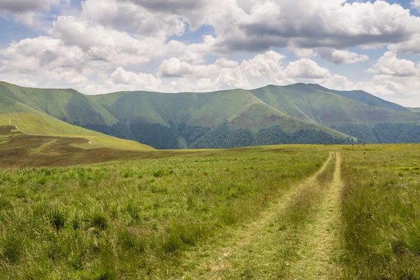 Montanhas verdes e céu azul nublado — Fotografia de Stock