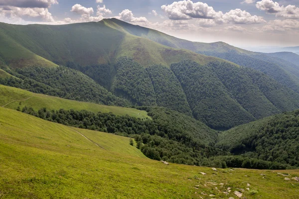 Montañas verdes y cielo azul nublado — Foto de Stock