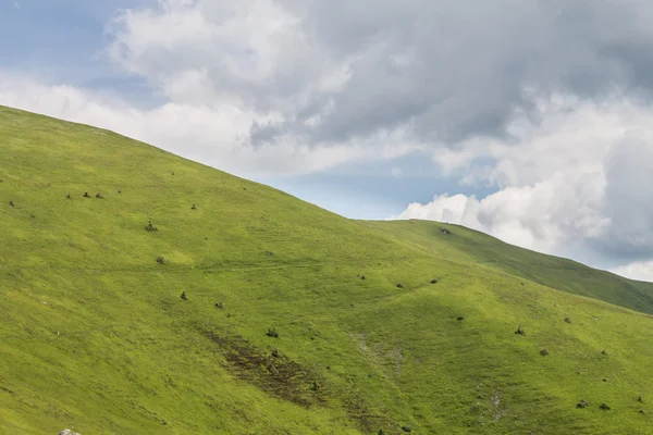 Montanhas verdes e céu azul nublado — Fotografia de Stock