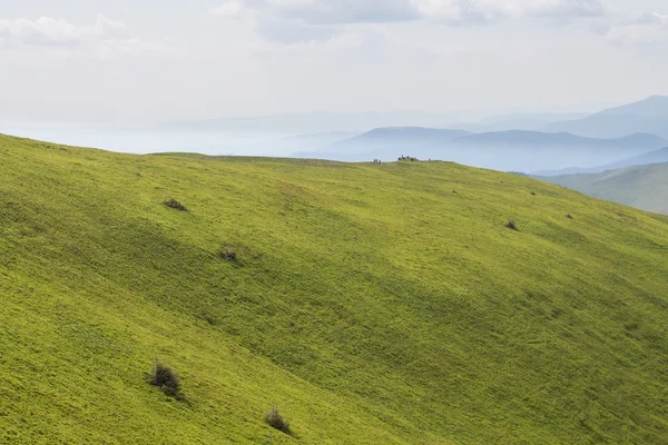 Montañas verdes y cielo azul nublado — Foto de Stock