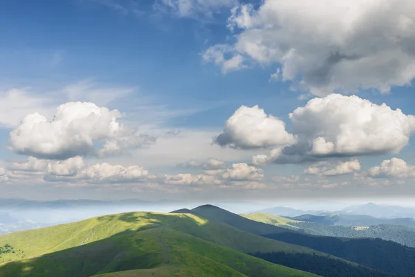 Montagnes vertes et ciel nuageux bleu — Photo