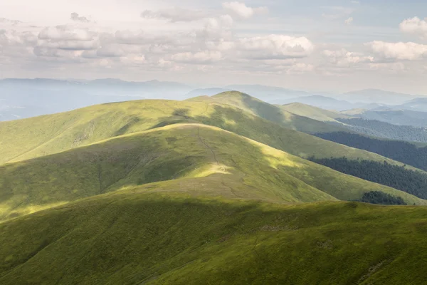 Montanhas verdes e céu azul nublado — Fotografia de Stock