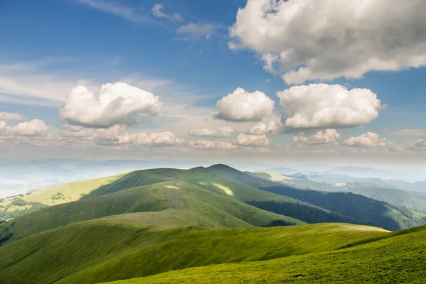 Montagnes vertes et ciel nuageux bleu — Photo