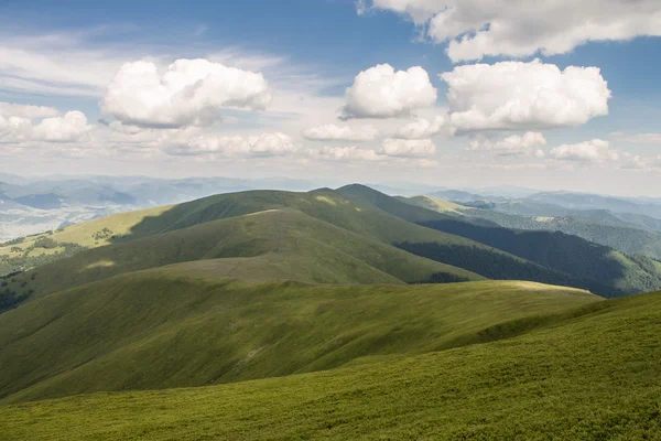 Montagnes vertes et ciel nuageux bleu — Photo