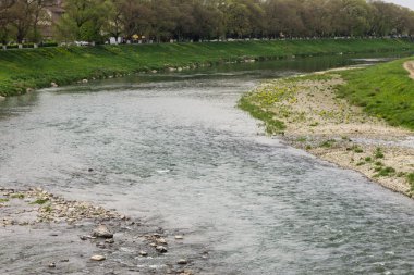 Nehir akışı kasaba ve bankalar üzerinde yeşil çimen
