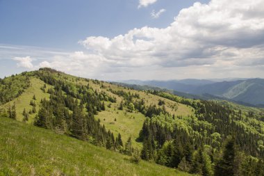 Beyaz bulutların üstünde mavi gökyüzü manzara ile yeşil yaz dağlarda yolu
