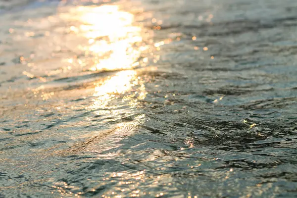 Deniz suyu yakınındaki kıyı şeridi arka plan günbatımı ışıkta dalgalar. — Stok fotoğraf