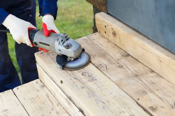 A carpenter worker is grinding a wooden surface with an electric sander. — Stock Image Carpenter Worker Grinding Wooden Surface Electric Sander Stock Image