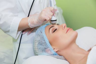 Genç bir kadın, yüz gerdirme ve yüz hatlarını düzeltme konusunda yalan söylüyor. Yakın plan..