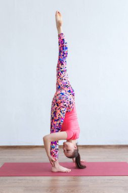 Beyaz arka planda izole edilmiş eğitim sırasında dikey sicim yapan güzel, genç ve formda bir kadın..