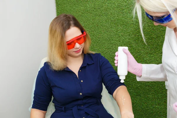 Нанесение контактного геля на руку перед лазерной эпиляцией — стоковое фото