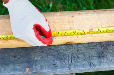 Ölçüm bandı ve kalemle erkek eli.