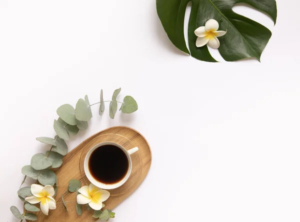 Tasse de café noir aux feuilles tropicales fraîches. — Photo