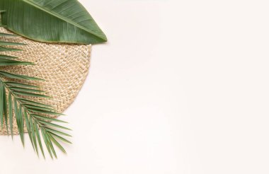 Yuvarlak hasır sehpa ve pembe arka planda palmiye yaprakları. Metin yeri ile fltlay biçimi kavramı