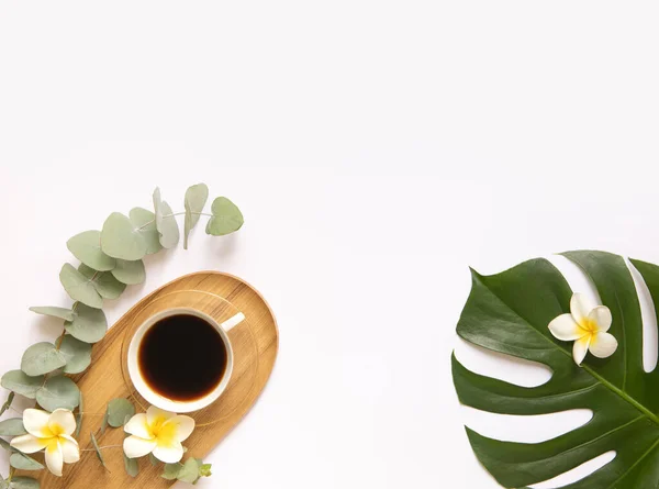 Tasse de café noir aux feuilles tropicales fraîches. — Photo