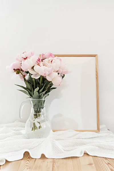 Moldura vertical mockup em uma mesa de madeira na cozinha. Vaso de vidro com um buquê de peônias rosa. Estilo escandinavo interior. — Fotografia de Stock