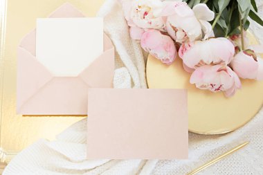 Düğün kartı konsepti. Ahşap arka planda şakayık çiçekleri olan üst görünüm. Açık renklerde düz uzanma biçimi.