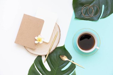 Tropik çalışma alanı konsepti. Not defteri ve tropik palmiye yaprakları. Model sunum çalışma yeri.