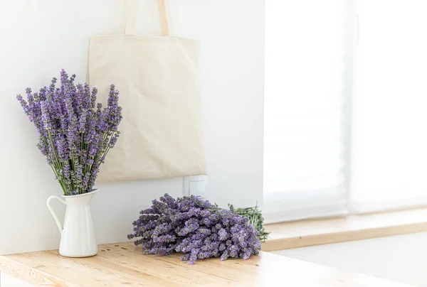 Un bouquet di lavanda all'interno di una cucina elegante. Mockup Eco-bag su un piano in legno. — Foto Stock