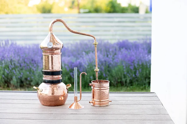 Destilación de aceite esencial de lavanda e hidrolato. Alambik de cobre para el campo de floración. —  Fotos de Stock