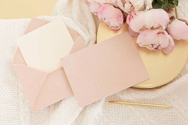 Düğün kartı konsepti. Ahşap arka planda şakayık çiçekleri olan üst görünüm. Açık renklerde düz uzanma biçimi.