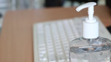 Coronavirus salgını sırasında evde çalışan bir ofis çalışanı ellerini dezenfektan jeliyle temizliyor ve koruyucu maske takıyor. Coronavirus, covid-19, evden çalışma, sosyal uzaklık konsepti. 4k