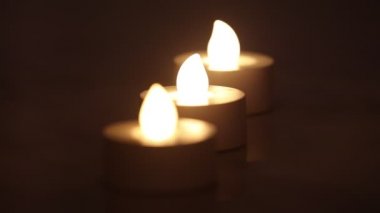 Koyu arkaplanı olan bir satırda üç yanan e-mum