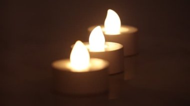 Koyu arkaplanı olan bir satırda üç yanan e-mum