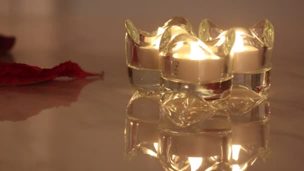 Tres velas electrónicas encendidas en un candelabro de cristal con Poinsettia — Vídeos de Stock