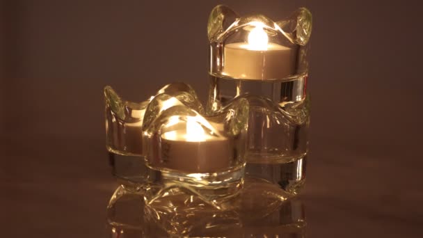 Três e-vela queimando em um suporte de vela de cristal — Vídeo de Stock