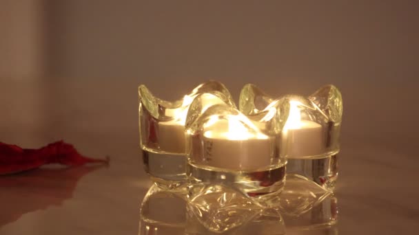 Tres velas electrónicas encendidas en un candelabro de cristal con Poinsettia — Vídeos de Stock