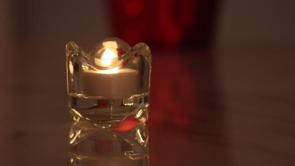 Vela electrónica ardiente en un candelabro de cristal con fondo rojo — Vídeos de Stock