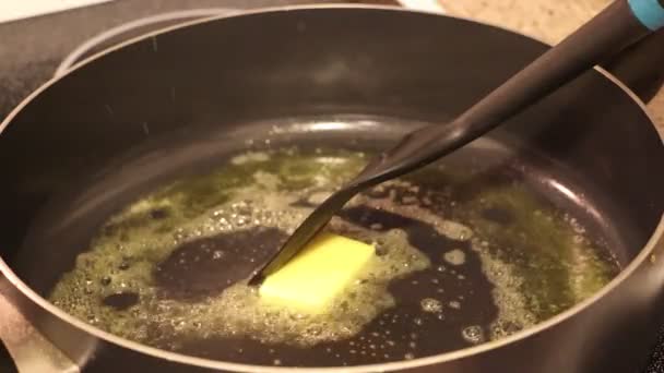 Beurre fondant grésillement dans la poêle sur la cuisinière. Gros plan. — Video