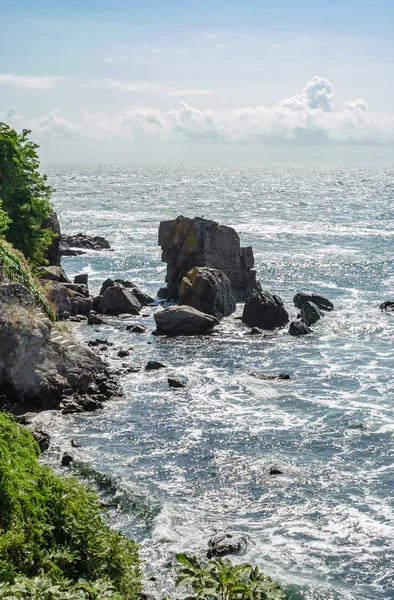 Sea wave raster om steniga stranden vid soluppgången — Stockfoto