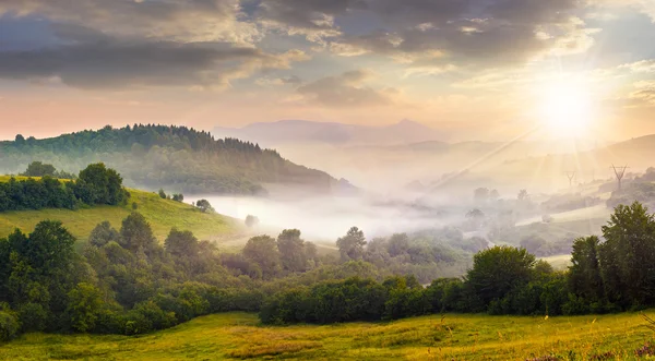 在农村地区在日落时的山坡上的雾 — 图库照片