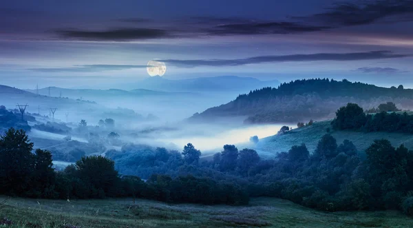 Nevoeiro na encosta na área rural à noite — Fotografia de Stock