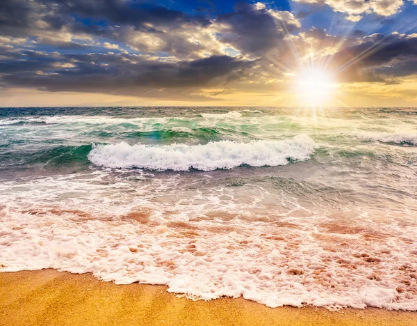 sea waves crashing on sandy beach at sunset — Stock Photo ...