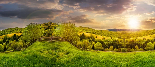 Recinzione sul prato collinare in montagna al tramonto — Foto Stock