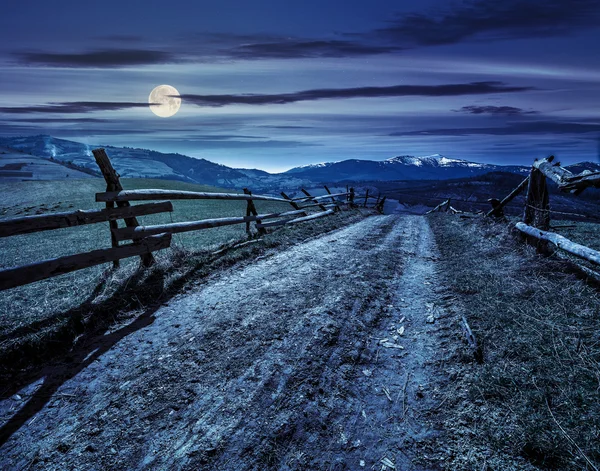 Rural area with snowy mountain tops at night — Stock Photo, Image