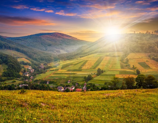 Meadow near village in autumn mountains at sunset — Stock Photo, Image