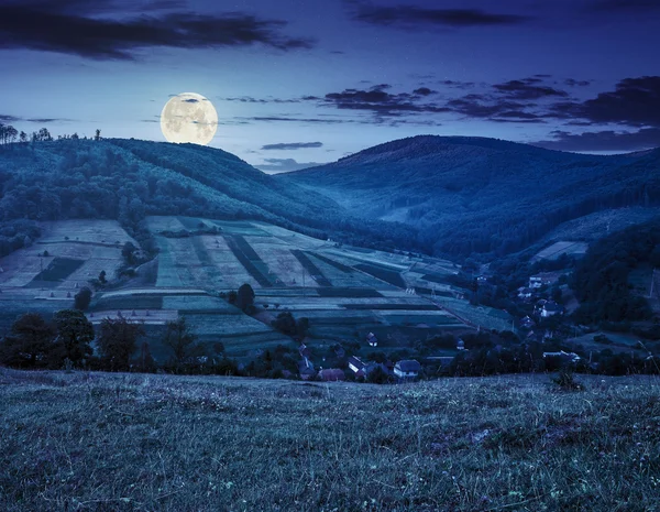 Prado perto da aldeia em montanhas de outono à noite — Fotografia de Stock