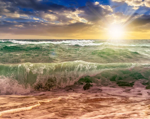 Vagues de mer énormes courant sur la plage de sable au coucher du soleil — Photo