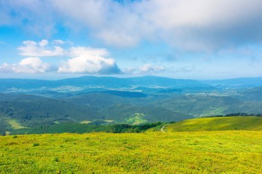 Yazın harika bir dağ manzarası. Doğada yeşil ve mavi renkler varsa güzellik. Dinamik bir gökyüzünün altındaki benekli ışıkta sersemletici dağ manzarası.
