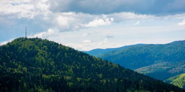 Dağ manzarasının kayan tepeleri. Karpat dağlarında bulutlu bir gün. Uzakta tepe var. İlkbaharda güzel doğa arka planı