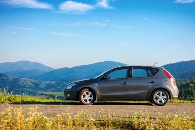 Araba sabah vakti dağın tepesindeki beton otoparkta. kırsal seyahat konsepti. Güzel doğa manzarası Yazın mavi gökyüzünde yumuşak bulutlar