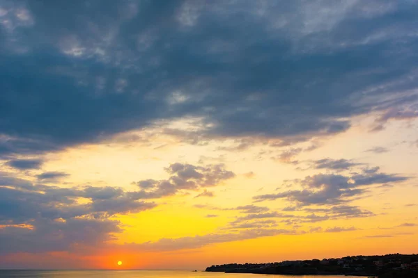 夏日日出时的多云景象 天空中乌云弥漫在黄色和粉色的晨光中 恶劣的天气状况 海面上风景如画的风景 — 图库照片