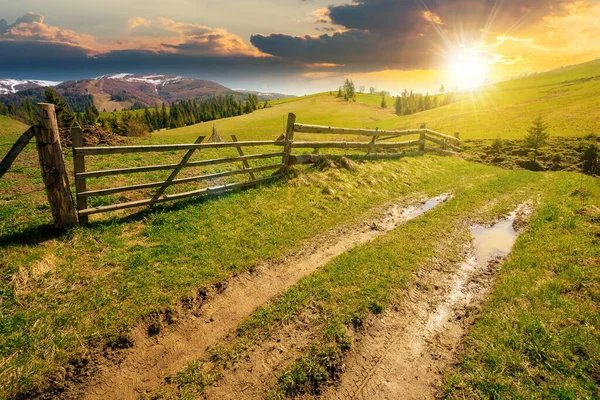 Bergslandskap Vid Solnedgången Våren Stig Genom Gräsplan Trästaket Böljande Kullar — Stockfoto