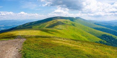 Dağ sırtı uzaklığa doğru ilerliyor. Gökyüzünde bulutlar olan harika güneşli bir hava. Karpat Dağları kavramını keşfetmek